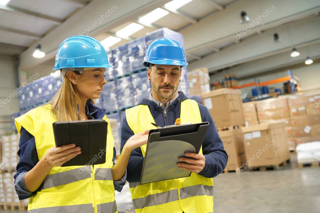 Workers in warehouse controlling incoming merchandise